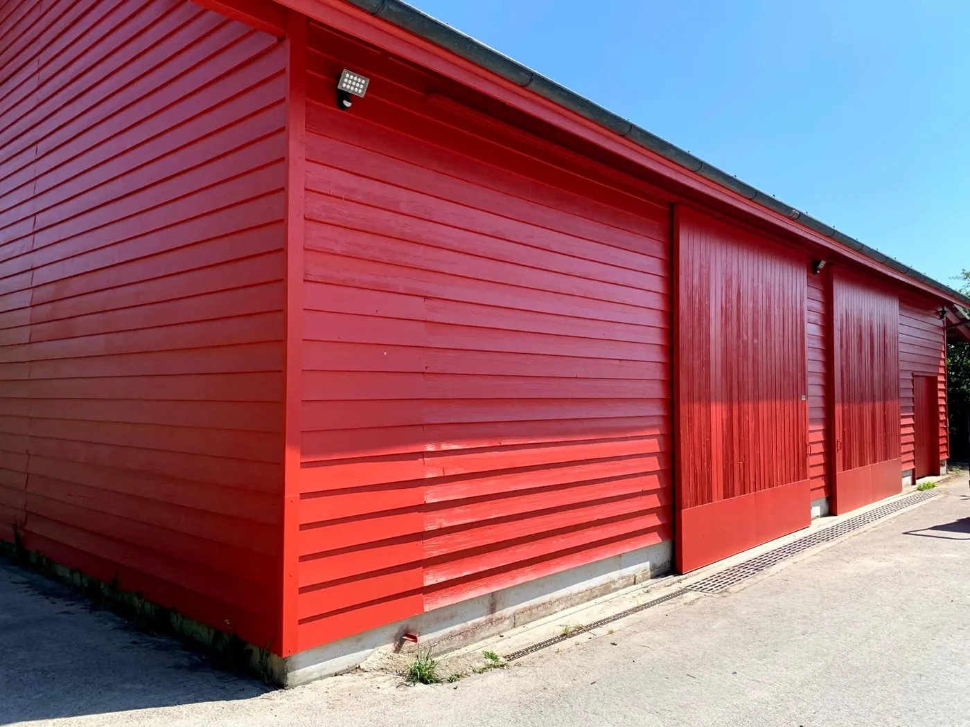 Porte de grange après : lames uniformes et teinte rouge tendue.